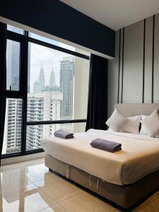 een slaapkamer met een groot bed en een groot raam bij KL SUITES AT AXON RESIDENCE KLCC in Kuala Lumpur