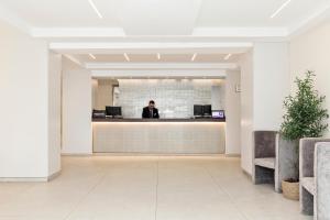 a man standing at a reception desk in a lobby at Hotel Best Auto Hogar in Barcelona