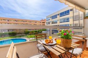 een balkon met een tafel en stoelen en een zwembad bij Vistamarina B208 by IVI Real Estate in Torremolinos