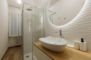 uma casa de banho com um lavatório branco e um chuveiro em Exphome em Novate Milanese