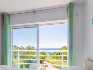 1 dormitorio con ventana grande con vistas al océano en Modern studio with AC and large terrace on the beach in Cavalaire - Welkeys en Cavalaire-sur-Mer