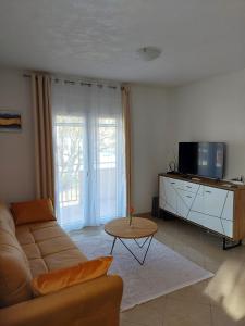 een woonkamer met een bank, een tv en een tafel bij Apartment Ivan in Trogir