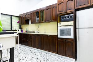 a kitchen with wooden cabinets and a white refrigerator at Luxury House since 1960 in Nazareth