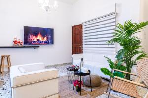 uma sala de estar com um sofá e uma televisão na parede em Luxury House since 1960 em Nazaré
