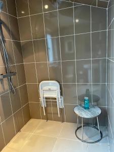 a shower stall with a stool and a stool at Neema in Barnstaple