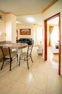 tourist house suites 2 في اوتابالو: غرفة معيشة مع طاولة وكراسي وأريكة