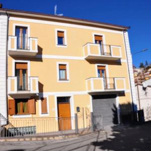 ein gelbes Gebäude mit weißen Fenstern und Türen in der Unterkunft Cappuccini Guest House in San Giovanni in Fiore