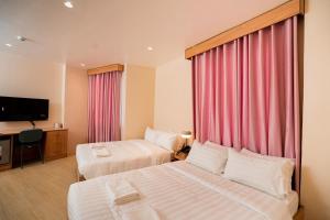 a hotel room with two beds and a flat screen tv at JVJ HOTELS CORPORATION in Batangas City