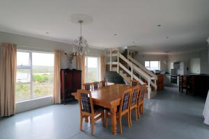 Un comedor con mesa y sillas de madera. en Will's Place, en Struisbaai
