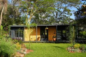 una casa en un jardín con patio en Pumbaa Farmhouse + Cottages, en Nairobi