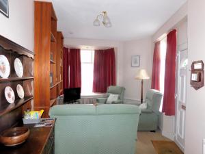 a living room with two chairs and a couch at Old Schoolyard Cottage in Sheringham