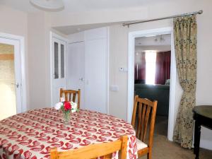 a dining room table with a red and white table cloth at Old Schoolyard Cottage in Sheringham