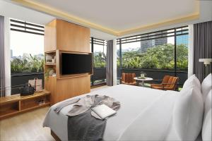 a bedroom with a large bed and a television at ARTOTEL Casa Kuningan in Jakarta