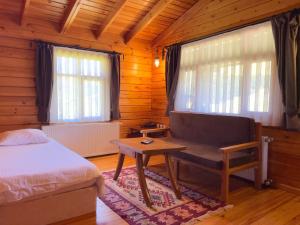 a bedroom with a bed and a bench and windows at Birun Kumbet Dag Evi in Kumbet