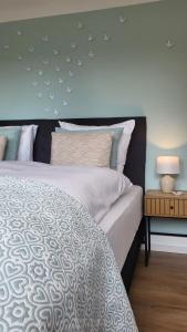 ein Schlafzimmer mit einem großen Bett mit blauer Wand in der Unterkunft Ferienwohnungen in Losheim am See - Gästehaus am Bachlauf - in Losheim