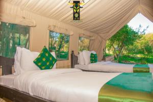 a bedroom with two beds in a tent at Mara Olodare in Ololaimutiek