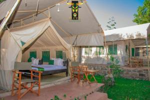 a tent with a bed and a table and chairs at Mara Olodare in Ololaimutiek