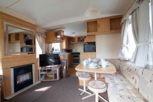 a living room with a couch and a table in a caravan at Skegness Caravans in Skegness