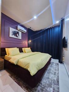 a bedroom with a large bed with a purple wall at Genesis Grid Homes "Aspen" in Lagos
