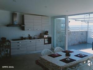 una cucina con tavolo e una cucina con vista di PALOMERA LUXURY APARTMENT SUL MARe a Gaeta