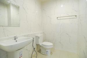 La salle de bains blanche est pourvue d'un lavabo et de toilettes. dans l'établissement Kandanai Place, à Ban Du