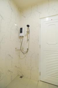 uma casa de banho com um chuveiro e um telefone na parede em Kandanai Place em Ban Du