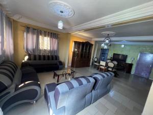 sala de estar amplia con sofás y TV en Chez Mimi, en Toubab Dialaw