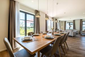 a dining room with a wooden table and chairs at Inseldomizil Stolpe - Urlaub unter Reet auf Usedom in Stolpe auf Usedom