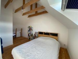 um quarto com uma cama branca num sótão em Maison 3 chambres proche mer em Le Relecq-Kerhuon