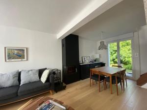 uma sala de estar com um sofá e uma mesa em Maison 3 chambres proche mer em Le Relecq-Kerhuon