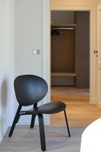 a black chair sitting in a room with a closet at Residence9Bruges in Bruges