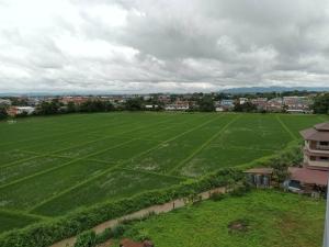 an aerial view of a large green field at Kandanai Place in Ban Du