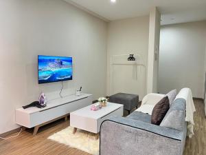 a living room with a couch and a tv on the wall at Setapak Cozy 4-6 Pax Suite ZetaPark by CITYSPACE in Kuala Lumpur