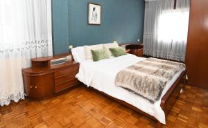 a bedroom with a large bed with white sheets and green pillows at Casa Juncal sin cocina in Vilaboa
