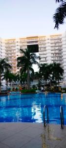 a large swimming pool in front of a large building at Sea Residences- Eliazar in Manila