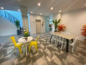 a dining room with yellow chairs and tables in a room at Kandanai Place in Ban Du