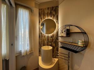 bagno con lavandino e specchio a parete di SKYLINE- 3 Apartments with view a Siena