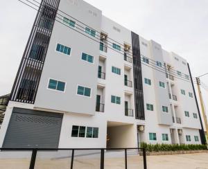 a large white building with green windows at Kandanai Place in Ban Du