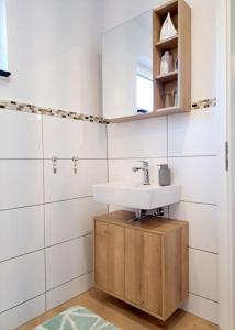 La salle de bains est pourvue d'un lavabo et d'une armoire en bois. dans l'établissement Schönes 1-Zimmer-Appartement, Büsum (4km) Nordsee, à Oesterdeichstrich