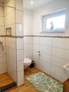 uma casa de banho com um WC, um lavatório e uma janela em Schönes 1-Zimmer-Appartement, Büsum (4km) Nordsee em Oesterdeichstrich