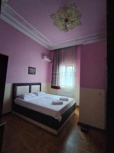 um quarto com uma cama grande e paredes roxas em BK GOLD HOTEL em Batumi