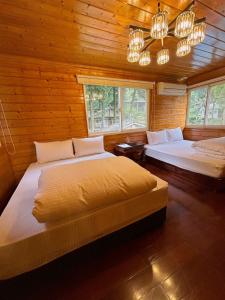 南庄乡南苑莊園 NanYuan Resort Manor的配有木墙和窗户的客房内的两张床