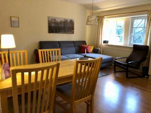 uma sala de estar com uma mesa e um sofá azul em Ferienwohnung Margret und Kord Hedder em Bispingen