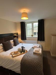 a bedroom with a bed with a tray of food on it at Norwood Cottage in Kirkby Lonsdale