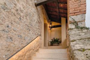 a staircase leading up to a stone building with a potted plant at Dimora storica Torre dei Petricci 12 in Sovicille