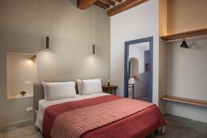 a bedroom with a large bed with a red blanket at Dimora storica Torre dei Petricci 12 in Sovicille +13 photos