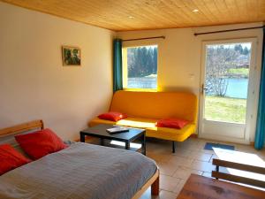 ein Schlafzimmer mit einem Bett, einem Sofa und einem Fenster in der Unterkunft Domaine du Balbuzard in Condat-en-Combraille