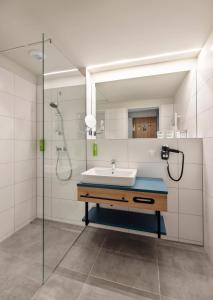 y baño con lavabo y ducha. en JUFA Hotel Bad Radkersburg - inkl 4h Thermeneintritt, en Bad Radkersburg