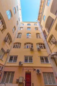 ブダペストにあるHeart of Budapest Apartmentの赤い扉の高い黄色の建物