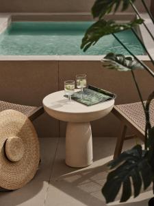 dos copas de vino sentadas en una mesa en un balcón en Domus Blanc Boutique Hotel, en La Canea